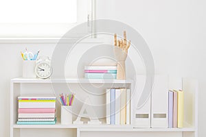 Shelves with school supplies in child room close-up beneath window