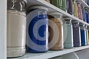 Shelving with glass jars of colorful pigments