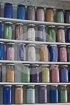 Shelving with glass jars of colorful pigments