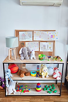 Shelving with lots of  colorful organized toys at kindergarten