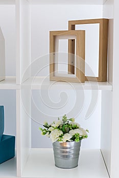 Shelving unit flower and frames photo