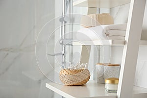 Shelving unit with toiletries in bathroom interior