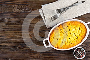 Shepherd's Pie or Cottage Pie, traditional British dish on brown wooden backgfound