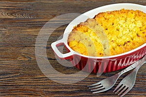 Shepherd's Pie or Cottage Pie, traditional British dish on brown wooden backgfound
