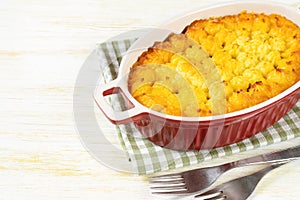 Shepherd's Pie or Cottage Pie, traditional British dish on white wooden backgfound