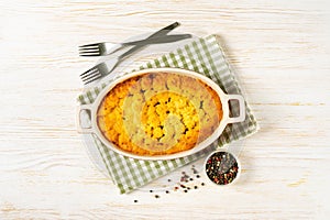 Shepherd's Pie or Cottage Pie, traditional British dish on white wooden background