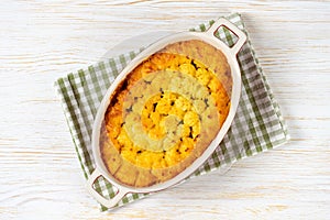 Shepherd's Pie or Cottage Pie, traditional British dish on white wooden background