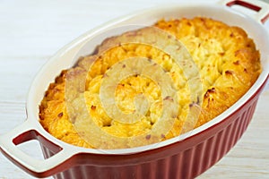 Shepherd's Pie or Cottage Pie, traditional British dish on white wooden background