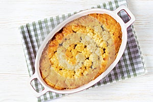 Shepherd's Pie or Cottage Pie, traditional British dish on white wooden background