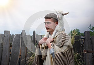 Shepherd with a sheep in his arms