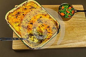 Shepherds or cottage pie in serving dish, one portion taken, with spoon