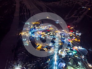 Sheregesh Kemerovo region ski resort in winter, night landscape on mountain and hotels, aerial view