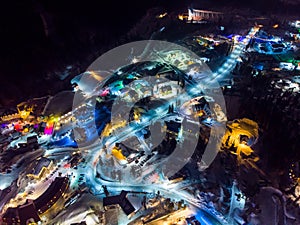 Sheregesh Kemerovo region ski resort in winter, night landscape on mountain and hotels, aerial view