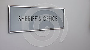 Sheriff office door, hand knocking, law enforcement officer, crime prevention