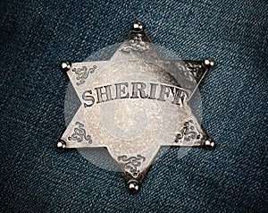 Sheriff star badge on blue denim background