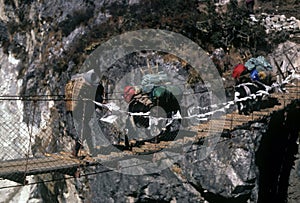 Sherpa and yaks crossing suspension bridge