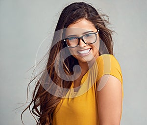 Shes authentically beautiful. Studio portrait of an attractive young woman posing against a grey background.