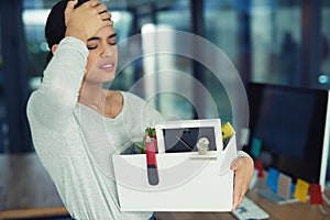 Shes been laid off from work. an unhappy businesswoman holding her box of belongings after getting fired from her job.