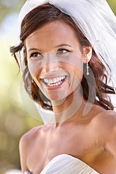 Shes a blushing bride. Gorgeous young bride looking away in her wedding dress and veil.