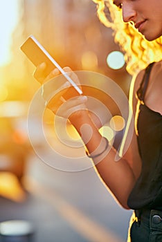 Shes connected to the city. an attractive young woman sending a text while walking around the city.