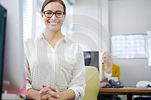 Shes the consummate young professional. Portrait of a young woman sitting at her desk in an office.