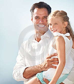 Shes daddys little girl. A happy father carrying his adorable daughter as they enjoy a day in the sun.
