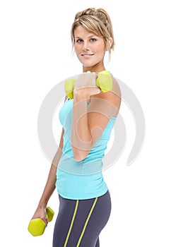 Shes determined to stay in shape. Attractive young woman in sportswear lifting dumbbells while isolated on white.
