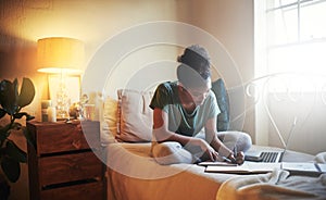 Shes a diligent student. Full length shot of a young female student studying at home.