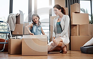 Shes excited to start unpacking. Full length shot of an attractive young woman and her daughter moving into a new house.