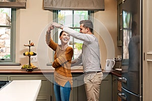 Shes forever his princess. Shot of an affectionate young couple dancing together in their kitchen at home.