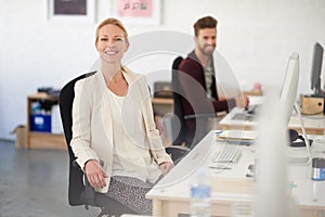 Shes found the right career space for her. Portrait of a smiling businesswoman sitting at her desk with her colleague in