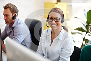 Shes got all the qualities of a great salesperson. Shot of customer service representatives taking calls in their office