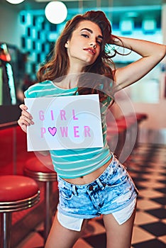 Shes got it. Cropped portrait of an attractive young woman holding up a sign in a retro diner.