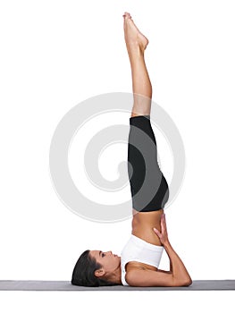 Shes got perfect balance. A young woman doing yoga stretches while isolated on white.