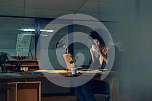 Shes got a strong cuppa to keep her going. Cropped shot of a young businesswoman working late on a laptop in an office.