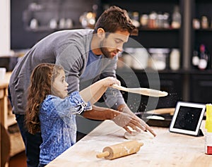 Shes got talent. Shot of a father and daughter working with pizza dough in the kitchen.