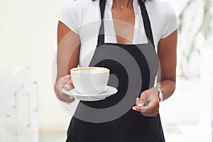 Shes got what you need. a waitress carrying a cup of coffee.