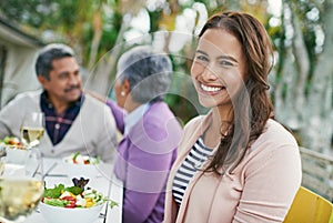 Shes happiest at home. Cropped portrait of a young woman having lunch with her parents outside.