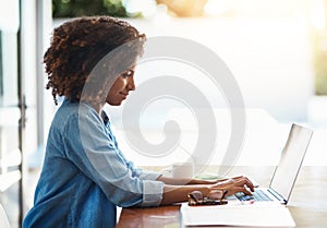 Shes always hard at work. an attractive young woman working on her laptop at home.