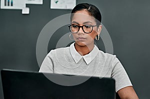 Shes highly committed to succeeding in business. a young businesswoman working on a laptop in an office.