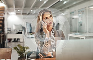 Shes on an important business call. an attractive mature businesswoman making a phonecall while working in her office.