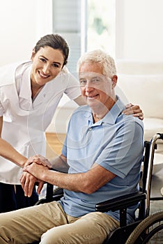 Shes an indispensible helper. Portrait of a smiling caregiver and a senior man in a wheelchair at home.