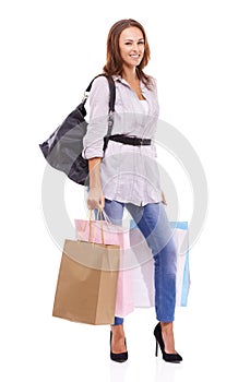 Shes just got back from a successful shopping trip. Smiling young woman holding some boutique shopping bags - isolated