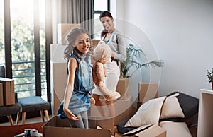 Shes making moving day fun. an attractive young woman and her daughter moving into a new house.