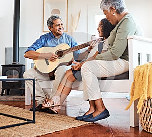 Shes mesmerised. a grandfather playing guitar for his grandchild at home.