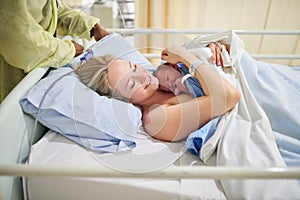 Shes my heart in human form. a beautiful young mother lying in bed with her newly born baby girl in the hospital.
