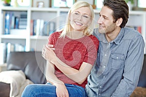 Shes my special girl. a young couple sitting together in their living room.