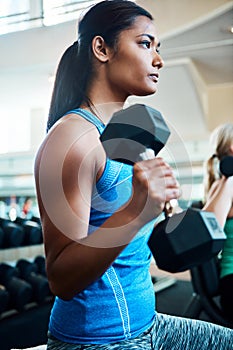 Shes never shied away from hardwork. an attractive young woman working out with dumbbells at the gym.