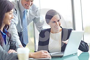 Shes showing them some of the latest figures. three businesspeople having a discussion at a conference table with a