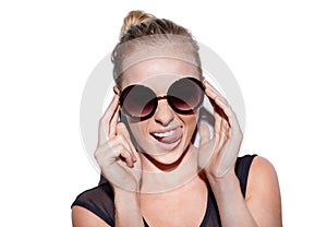 Shes a spunky girl. Portrait of an attractive young woman with sunglasses posing playfully in studio.